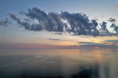 Hırvatistan 'ın Istria kıyısında, sakin Adriyatik Denizi üzerindeki dramatik akşam bulutları, sudaki yumuşak yansımalarla.
