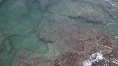 Şeffaf deniz suyu kayalık kıyı şeridinde yavaşça akıyor. Küçük doğal havuzlar ve köpüklü dalgalarla. Doğa, seyahat ve kıyı teması için mükemmel. Hava aracı görüntüsü. Istria, Hırvatistan.