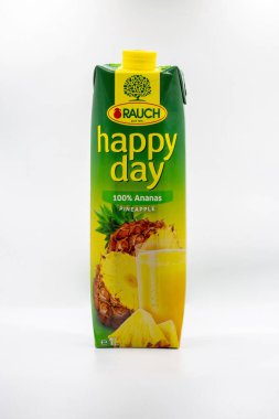 Tar, Croatia - May 29, 2025: Rauch Happy Day pure pineapple juice in one liter Tetra Pak carton with vibrant green and yellow packaging closeup on clean white background with fruit imagery.