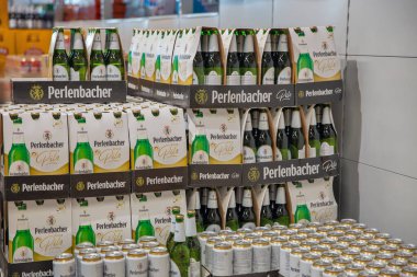 Porec, Croatia - May 31, 2025: Shelf display of Perlenbacher Pils beer bottles and cans in Lidl supermarket, showing branded packaging and stacked beverages for sale.