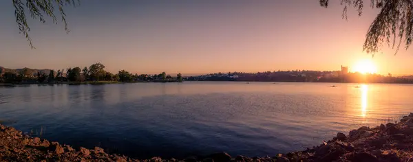 stock image Panoramic view of Saint Roque Lake in Villa Carlos Paz at sunset while people enjoy rowing.