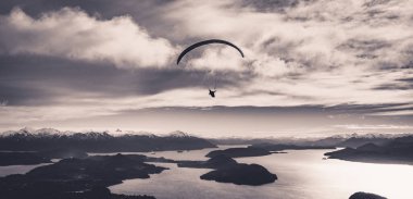 Arjantin 'deki Bariloche dağları ve Nahuel Huapi Gölü' nün arka planında siyah-beyaz tepeler olan panoramik bir manzara. Özgürlük kavramı, macera, uçmak..