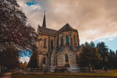 BARILOCHE, ARGENTINA, 18 Haziran 2019: Nuestra Senora del Nahuel Huapi Katedrali 'nin yanındaki kırmızı ağaçlı renkli yol