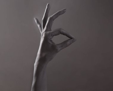 Tamam imzala. El iyi niyet göstergesi. Siyah boyalı kadının eli yüzük işareti yapıyor. Konsept: depresyonla başa çıkma, kişisel gelişim. 