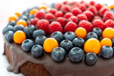 Yakın plan çikolatalı pasta ve üstünde taze böğürtlen..