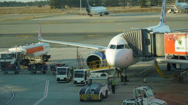 Kıbrıs Rum Kesimi, Larnaka - 12 Ekim 2022: Uçak havalimanında kalkış kolunda. Bir uçuş hazırlıyorum: yolcu köprüsü eklenmiş bir uçak