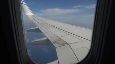 Uçağın kanadı, yolcu manzarası. Parlak kanadında bir uçağın penceresinden bakıyorum.