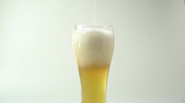 Bardağa köpüklü bira dolduruyorum. Bira üstten bardağa doluyor ve köpük oluşturuyor.