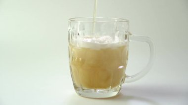 Bardağa köpüklü bira dolduruyorum. Bira üstten bardağa doluyor ve köpük oluşturuyor.