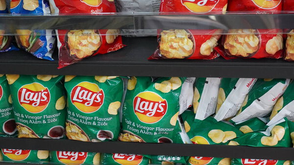 Limassol, Cyprus - 12.10.2022: A shelf with many packs of Lays Chips, Salted.