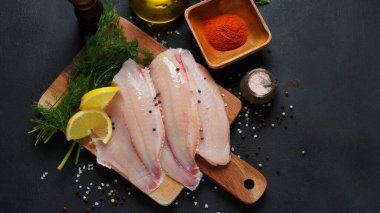 Biftek ya da salata için dilimlenmiş taze tilapia balığı fileto baharatları ve limonlu salata.