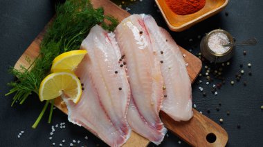 Biftek ya da salata için dilimlenmiş taze tilapia balığı fileto baharatları ve limonlu salata.