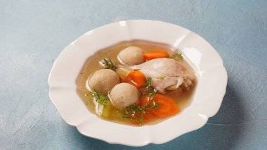 Diz kapaklı yahudi tavuk çorbası (matza yemeğinden yapılan toplar). Matzo topu çorbası.