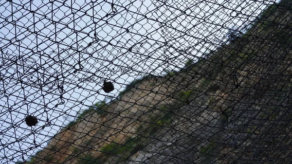 落石落石防潮堤の壁 金属網は落石を防ぎます — ストック写真