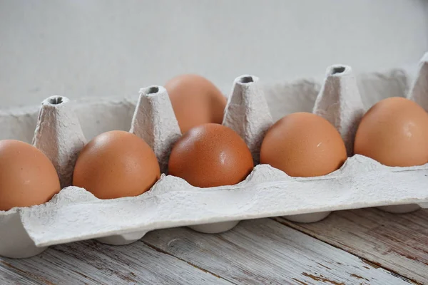 Brown eggs in carton with white background