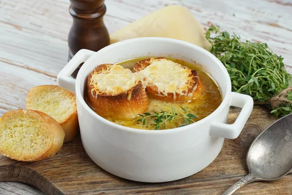 A classic French Onion Soup with with gruyere cheese and toasted baguette in a bowl