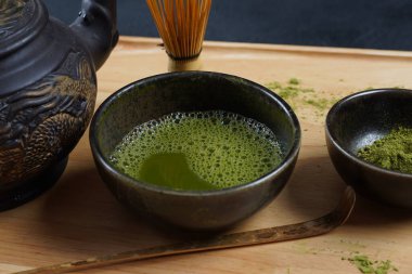 Geleneksel bir Japon çay töreninde olduğu gibi bambu çırpıcı ve kepçe ile yeşil kibrit çay tozu.
