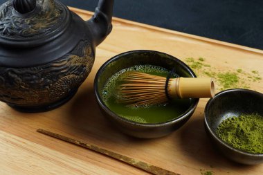 Geleneksel bir Japon çay töreninde olduğu gibi bambu çırpıcı ve kepçe ile yeşil kibrit çay tozu.