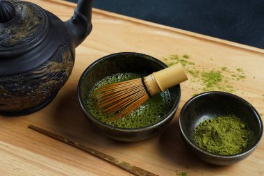 Geleneksel bir Japon çay töreninde olduğu gibi bambu çırpıcı ve kepçe ile yeşil kibrit çay tozu.