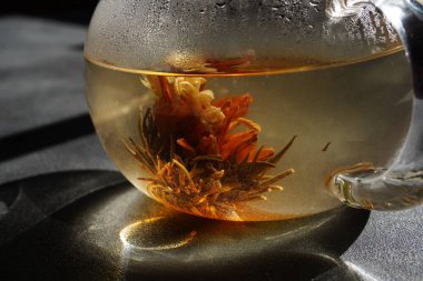 Güneş ışınlarında çiçek açan yeşil çaydanlık.