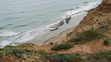 Yazın güzel deniz kıyısı. Sakin mavi deniz manzarası. Taşlı ve kumlu deniz kıyısı. Güneşli deniz manzarası. Netanya Şehri, İsrail