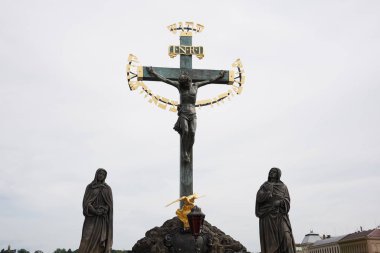 Çek Cumhuriyeti Prag 'daki tarihi Charles Köprüsü üzerindeki kutsal haçın heykeli..