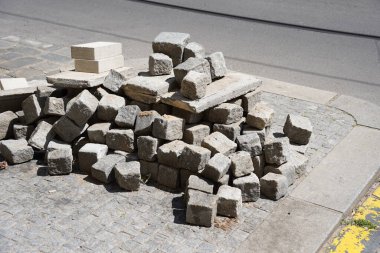 Bir yığın bloğu olan hasarlı bir yol, kaldırımda kırılıyor, gri bloklarla kaplanıyor. Kötü yol..