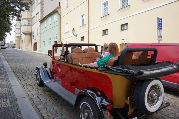 PRAGUE, Çek Cumhuriyeti - 8 Temmuz 2023: Prag sokaklarını gezmek için kullanılan kırmızı eski araba. Bu arabalar genellikle Prag 'ı ziyaret eden turistler tarafından kiralanır.