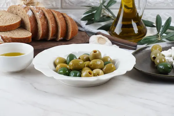Colorful Olives, olive branch, Olive oil in a bowl background