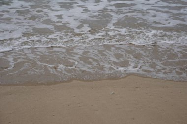 Akdeniz dalgaları kumlu bir plaja çarpıyor.