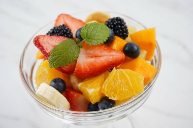 Portakallı, çilekli, böğürtlenli, böğürtlenli ve naneli yaz meyve salatası. Sağlıklı yemek.