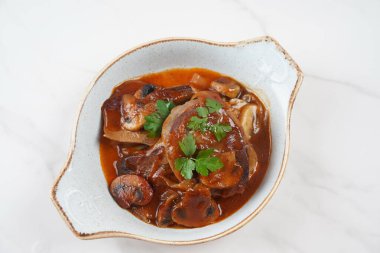 Mantarlı ve soğanlı yavaşça pişirilmiş sığır dili.