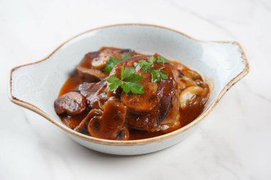 Mantarlı ve soğanlı yavaşça pişirilmiş sığır dili.