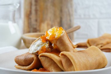 Kahvaltı için tatlı süzme peynirli krep ve şeftali reçeli.