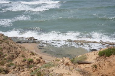 Baharda Akdeniz 'de. İsrail 'in Herzliya ve Netanya kasabaları arasındaki Akdeniz kıyı şeridi üzerinde terk edilmiş kıyı kayalıkları doğa rezervi..