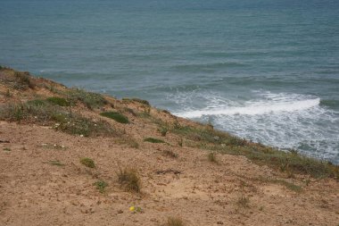 Baharda Akdeniz 'de. İsrail 'in Herzliya ve Netanya kasabaları arasındaki Akdeniz kıyı şeridi üzerinde terk edilmiş kıyı kayalıkları doğa rezervi..