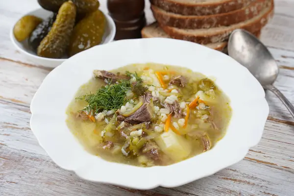 stock image Soup with beef meat, pickled cucumbers and pearl barley.  Rassolnik- traditional Russian cuisine cucumber soup
