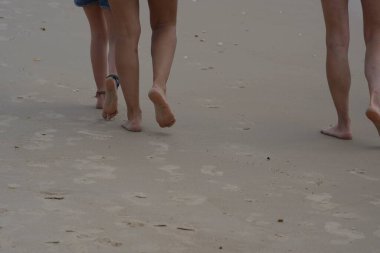 Yalınayak kumsalda yürüyor