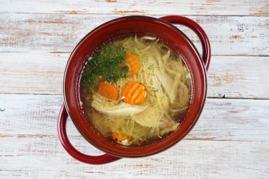 Tavuk çorbası, tavuk çorbası, saplı kırmızı kasede tavuk ve sebze parçaları. Tavuk buili, haşlanmış et.