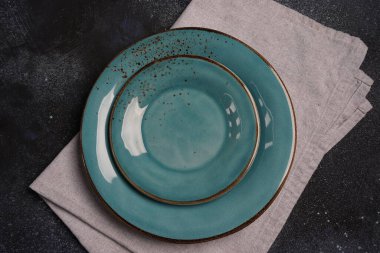 İki boş mavi seramik tabak karanlık masada.