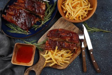 Barbekü soslu ızgara domuz pirzolası ve balda karamelize edilmiş. Baharatlı ızgara domuz kaburgası ve patates kızartması.