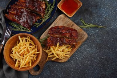 Barbekü soslu ızgara domuz pirzolası ve balda karamelize edilmiş. Baharatlı ızgara domuz kaburgası ve patates kızartması.