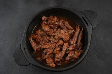 Dökme demir tavada sığır eti güveci. Dilimlenmiş et parçaları.