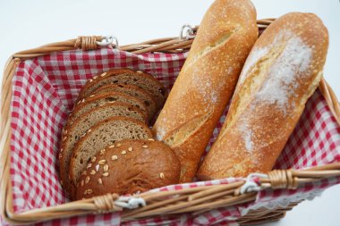 Bir soğan ekmeğinin yarısı ve piknik sepetinde tatlı pekmez kahverengi ekmek dilimleri, Fransız ekmeği.