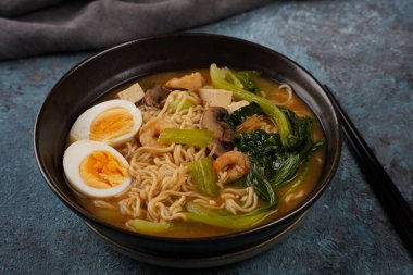 Karidesli Asya ramen çorbası, kızarmış tofu ve mantarlı kase..