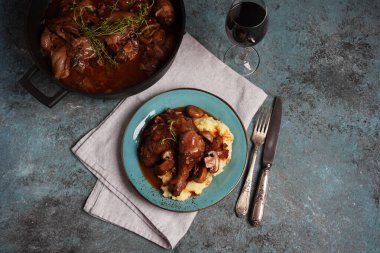 Coq au vin veya horoz, şaraplı horoz. Burgundy soslu Fransız tavuğu. Kırmızı şarap, pastırma, mantar ve soğanla pişirilmiş. Tuz, biber ve kekik ile tatlandırılmış.