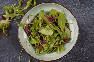 Sağlıklı salata yaprakları koyu taş ya da beton arka planda karışır