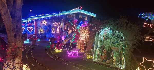 stock image exterior facade of traditional house with lots of lights decorated for christmas by night