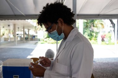 Rio de Janeiro, Brezilya - 19 Mart 2021: 75 yaşındaki erkekler Rio de Janeiro.Coronavirus 'un kuzey bölgesindeki UERJ Kampüsü Maracan' da CoronaVac ile aşılandılar.