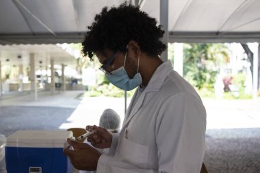 Rio de Janeiro, Brezilya - 19 Mart 2021: 75 yaşındaki erkekler Rio de Janeiro.Coronavirus 'un kuzey bölgesindeki UERJ Kampüsü Maracan' da CoronaVac ile aşılandılar.